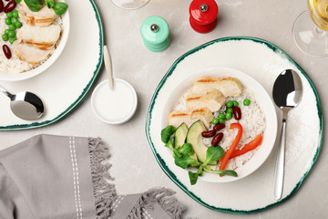 Boiled rice with vegetables and meat served on table, flat lay