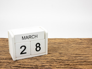 March 28 white cube wooden calendar on vintage wood and white background with Spring day, Copyspace for text