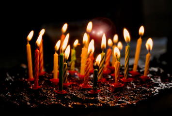 Homemade chocolate birthday cake with lit candles ready for celebration, outdoor setting, natural light, festive atmosphere, sweet dessert for birthday song moment, perfect for joyful party scenes