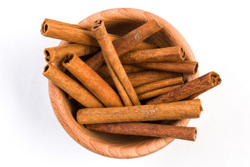 cinnamon sticks  in wooden bowl isolated on white background