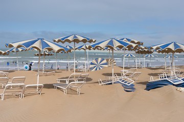 Schirme und Liegen nach dem Sandsturm am Strand von Agadir