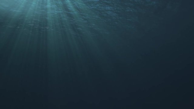 Seamless loop of a tranquil underwater scene with ocean waves and sun and light rays shining through - high quality 3d animation