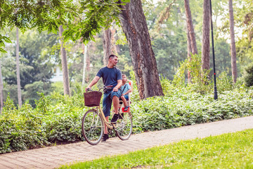 Family On Cycle Ride In Countryside- father and son riding a bicycle.