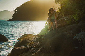 Sunny photo. Couple standing and hugging  jn the sea cost cliff