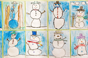 Children's art works on the wall in their school - pictures of snowmen