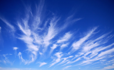 Cirrus cloud formations at high altitude over a deep blue sky.