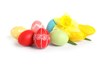 Colorful painted Easter eggs and spring flowers on white background