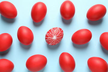 Flat lay composition of red Easter eggs on color background