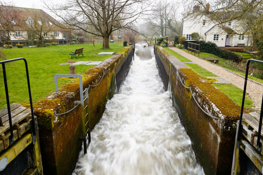 Flood waters racing through the mill race at Dedham Mill, near Flatford, Essex