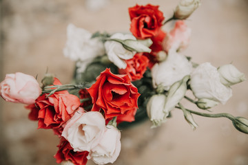 Bouquet of red Eustoma flowers in vase on blurred background