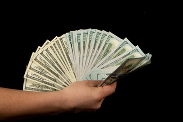 Fan of dollars in a male hand on a black background
