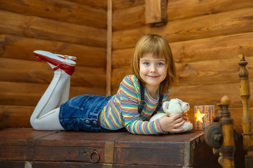 Girl Masha is lying on the old chest and smiling.