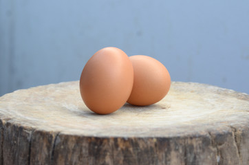 Two eggs placed on a wooden cutting board