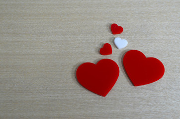 A white heart surrounded by a red heart on wood background