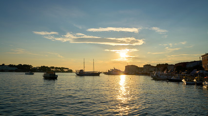 Sonnenuntergang mit Schiffen in der Hafenstadt Porec in Istrien in Kroatien