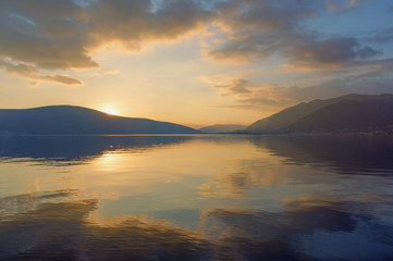 Beautiful sunset with mirror reflection on the water. Montenegro, Adriatic Sea, Bay of Kotor