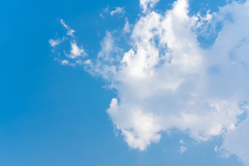 Sunlight hitting white streamy contrasting clouds in a blue clear sky