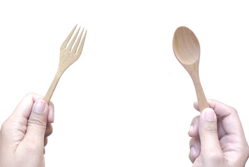 Woman hands hold wooden fork and spoon on white background