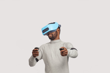 Fototapeta premium Stylishly dressed african guy using new VR technology headset, learning material and getting knowledge and practice through 3D video glasses. Virtual education concept