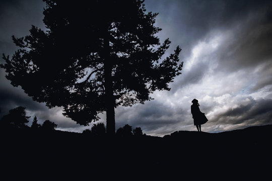 Depressed Young Woman Sitting Under The Tree