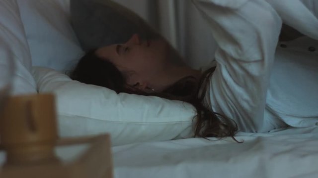 Beautiful girl waking up from pleasant dream stretching in bed in morning natural light 4k. Young woman sleeping lies smiling before getting up to work close up shot. Healthy lifestyle energy relax
