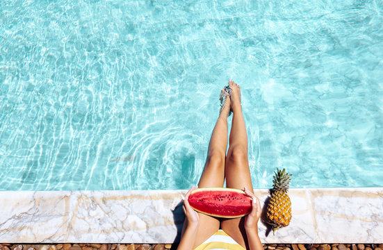 Girl eating watermelon by pool