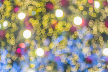 Fototapeta na wymiar Abstract blurred colorful Christmas tree lighting decoration with bokeh background. Defocused of decorated and illuminated christmas tree for Merry Christmas and new year festival celebration.