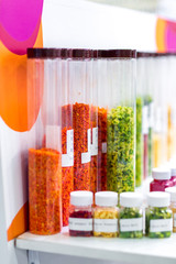 Dried vegetables in glass jars, onions, beets, carrots, pumpkin, bay leaf, banks on wooden background. Superfoods, herbs.