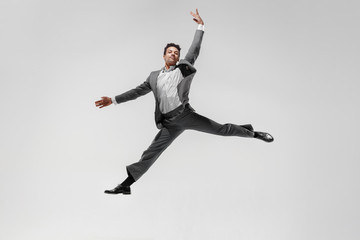 Fototapeta na wymiar Happy businessman dancing in motion isolated on white studio background. Flexibility and grace in business. Human emotions concept. Office, success, professional, happiness, expression concepts