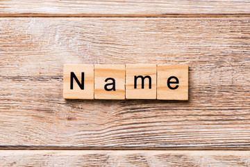 NAME word written on wood block. NAME text on wooden table for your desing, concept