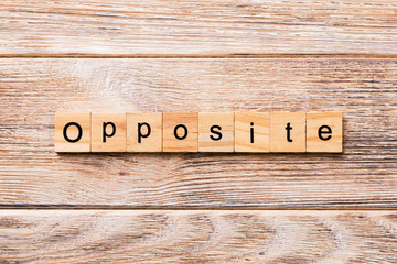Opposite word written on wood block. Opposite text on wooden table for your desing, concept