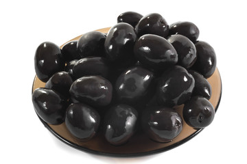Plate of black olives on a white background, close up. Food