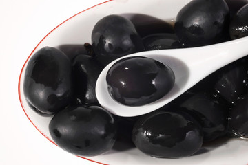 Plate of olives close, on a white background.
