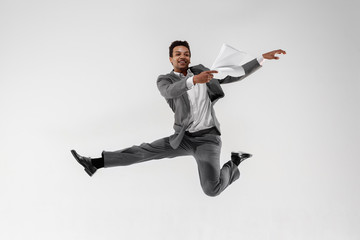 Happy businessman dancing in motion isolated on white studio background. Flexibility and grace in...