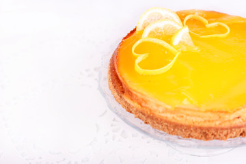 Lemon cheesecake on white background decorated with lemon zest close up
