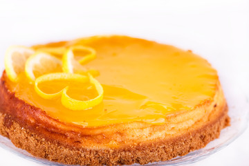 Lemon cheesecake on white background decorated with lemon zest close up