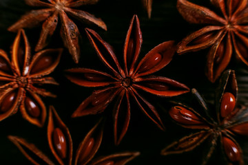 Spices of star anise on the old table. Rustic dark background, aroma close-up, macro.