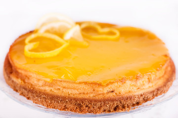 Lemon cheesecake on white background decorated with lemon zest close up