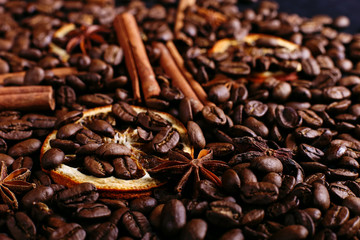 Cinnamon sticks, star anise, coffee beans and dried orange on the kitchen table. Fragrant spices for coffee drink, close-up.