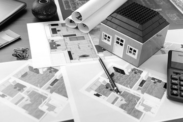 Drawings, layout of the house, documents, calculator on the desktop in the office. Engineering, construction, business.
