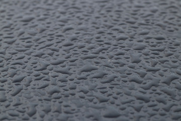 large drops on the surface of a gray car