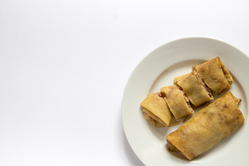 Two fried pancakes with ham and cheese filling on a white plate, white, gray background