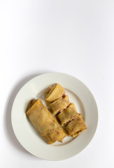 Two fried pancakes with ham and cheese filling on a white plate, white, gray background