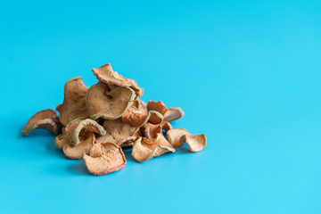 Obraz premium Dried Apples Slice In A Heap On blue Background, Ingredients For Turkish Apple Tea, Close Up. Homemade sun-dried organic apple slices
