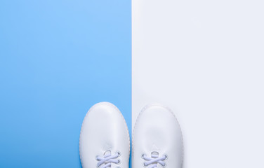 Pair of white sneakers and space for text on color background, flat lay, top view