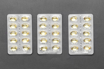 pills in a blister on a black background