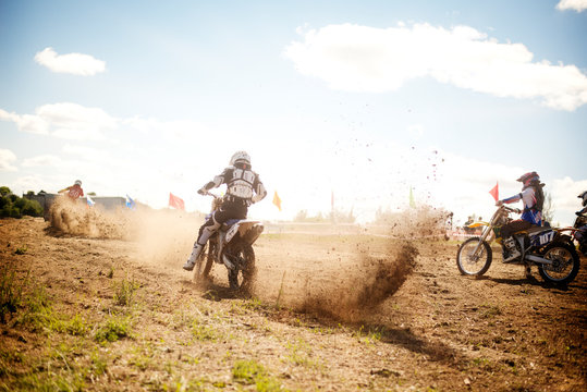 BMX rider kicking up dirt in a race 