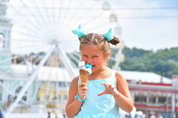 cute girl in a beautiful dress eating cone with multi-colored marshmallows