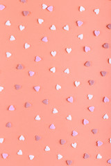 The heart shaped powder like candy is scattered on the table. Happy Easter concept greeting card design.