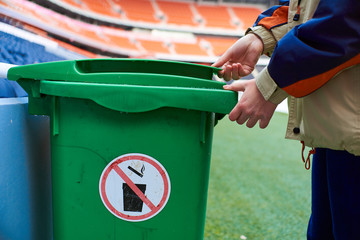 stadium worker opens trash can